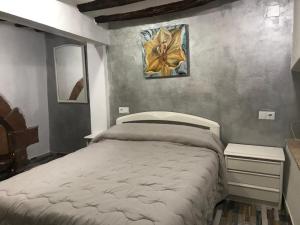 een slaapkamer met een bed en een schilderij aan de muur bij Casa Rural la Llar in Vilafames