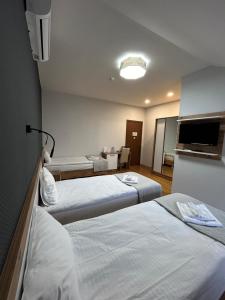 um quarto de hotel com duas camas e uma televisão em 10 KEYS Boutique Hotel em Borjomi