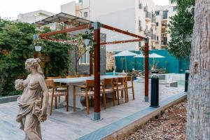 a patio with a table and chairs and an umbrella at Suite 5 at Palazzo Seraphim Boutique living in St Julians in St Julian's
