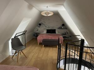 ein Schlafzimmer mit einem Bett und einem Stuhl im Dachgeschoss in der Unterkunft La Chaumière Roz-Aven in Pont-Aven
