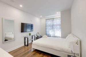 a white bedroom with a bed and a large window at M11 Upscale Studio wQueen Bed AC Prime Location in Montréal