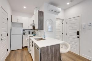 a white kitchen with white cabinets and a sink at M11 Upscale Studio wQueen Bed AC Prime Location in Montréal