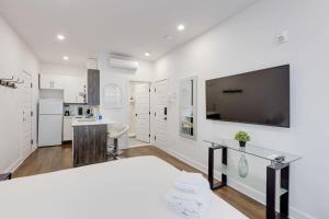 a kitchen with white walls and a large flat screen tv at M11 Upscale Studio wQueen Bed AC Prime Location in Montréal