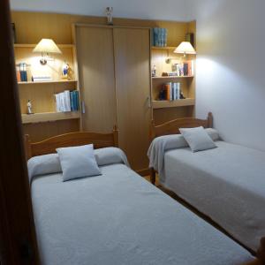 - 2 lits dans une chambre avec étagères dans l'établissement Maison typique Basque en pleine campagne, à Saint-Pée-sur-Nivelle