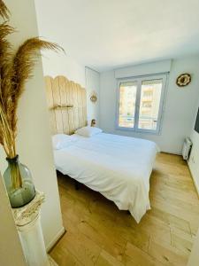 een slaapkamer met een groot wit bed en een raam bij Riviera’s Soul in Antibes