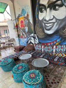 een muurschildering van een vrouw en stoelen voor bij Cecilia Hostel in Caïro