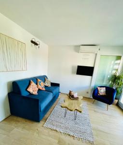een woonkamer met een blauwe bank en een tafel bij Riviera’s Soul in Antibes