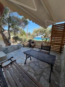 a bench and a table on a patio at K. Villa - Golden Beach in Chrysi Ammoudia