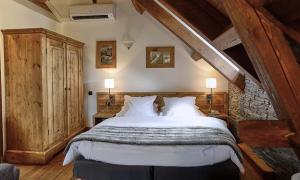 sypialnia z dużym łóżkiem na poddaszu w obiekcie Le Moulin de Lily w mieście Palaiseau