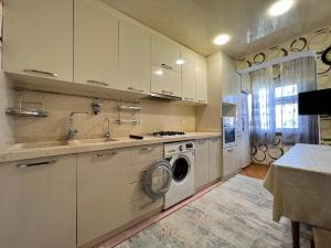 a kitchen with a sink and a washing machine at Cozy apartment in Baku