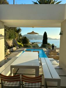 een patio met een tafel en stoelen naast een zwembad bij Villa JFK in Marseille