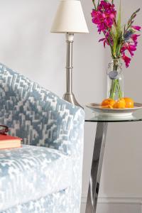 una mesa con una silla y un jarrón con flores en Anchor Watch with Parking, en Dartmouth