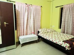 ein kleines Schlafzimmer mit einem Bett und einem Fenster in der Unterkunft Pebbles in Kozhikode