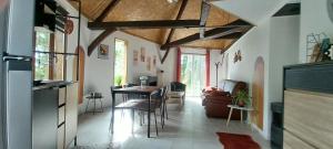 Una cocina y una sala de estar con mesa y sillas. en Le manège terre et mer proche Etretat, en Gonneville-la-Mallet
