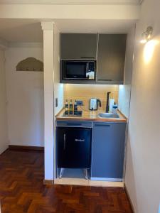 una piccola cucina con lavandino e forno a microonde di G3 Inn apartments a Mendoza