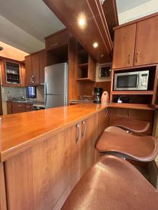 a kitchen with wooden cabinets and a stainless steel refrigerator at K. Villa - Golden Beach in Chrysi Ammoudia