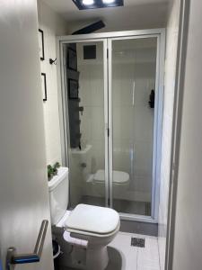 a bathroom with a toilet and a glass shower at G3 Inn apartments in Mendoza +9 photos