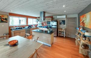a large kitchen with a table and a dining room at Stunning Home In Seignosse in Seignosse