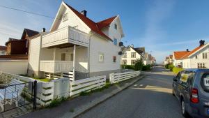 een wit huis met een hek naast een straat bij Central modern Lyse Fjord apartment in Stavanger