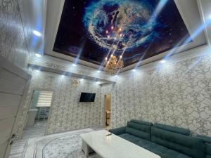 uma sala de estar com um sofá e uma pintura do universo na parede em Cozy apartment 3 em Samarkand