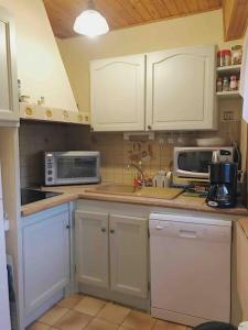 a kitchen with white cabinets and white appliances at Maison de montagne proche des Angles in La Llagonne
