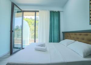 a bedroom with a large white bed with a window at Bamboo Beach Cixisdziri in Tsikhisdziri +29 photos