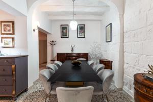 セントジュリアンズにあるSuite 4 at Palazzo Seraphim Boutique living in St Juliansの黒いテーブルと椅子のあるダイニングルーム