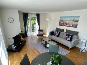 uma sala de estar com um sofá e uma mesa em Liberty Garden (Luxury 1bd Apt) em Portishead