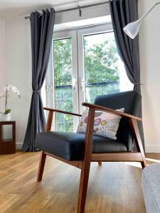 einen Stuhl im Wohnzimmer mit Fenster in der Unterkunft Liberty Garden (Luxury 1bd Apt) in Portishead