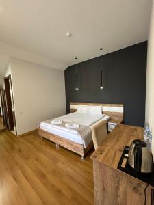 een slaapkamer met een bed en een bureau. bij 10 KEYS Boutique Hotel in Borjomi
