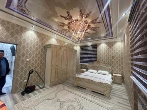 um quarto com uma cama e um lustre em Cozy apartment 3 em Samarkand