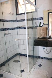 a glass shower in a bathroom with a sink at Lindo sitio com piscina em Rio Novo-Minas Gerais in Rio Novo