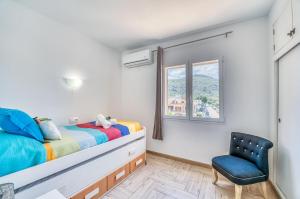 - une chambre avec un lit et une chaise bleue dans l'établissement Ideal Property Mallorca - Marvi, à Alcúdia