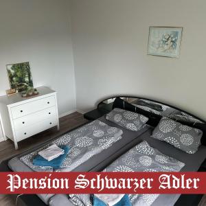a bedroom with a bed with pillows and a dresser at Pension Schwarzer Adler 