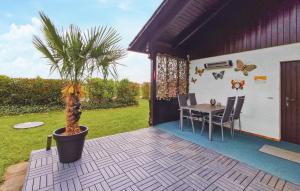 a patio with a table and a palm tree at Ferienhaus 1 In Thalfang in Thalfang