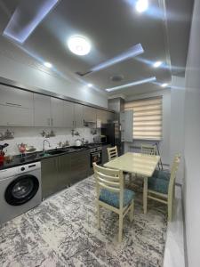 uma cozinha com uma mesa e cadeiras numa cozinha em Cozy apartment 3 em Samarkand