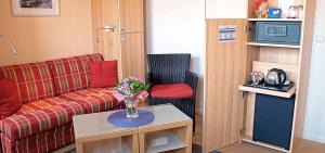 a living room with a couch and a table at Baltic Kölln Hotel in Heiligenhafen