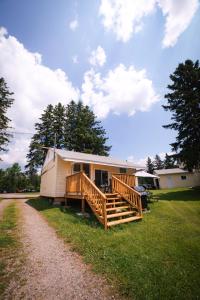 een stacaravan met een veranda en een terras bij Beachfront Cabin #5- Maijac Resort & Marina in Magnetawan