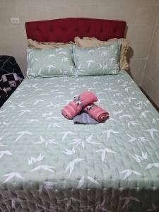 a pink purse laying on a bed with white birds on it at La Alborada Casa boutique in Villavicencio