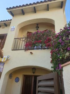 a building with a balcony with flowers on it at Lluna Beach Bará in Roda de Bará