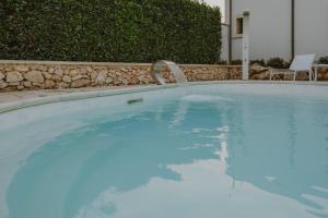 una piscina con una fuente de agua en Villa Patrizia Salento Art & Room en Porto Cesareo