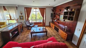 ein Wohnzimmer mit einem roten Sofa und einem Tisch in der Unterkunft CASA MEXILLOEIRA in O Grove