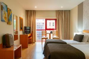 Habitación de hotel con cama y sala de estar. en Eurosol Residence en Leiria