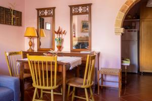 a dining room table with yellow chairs and a mirror at Private Art Studio 50m from sea (1-4 per) in Monemvasia