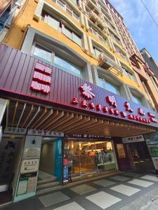 日初青旅 Sundaily Hostel 北車 في تايبيه: متجر أمام مبنى عليه لافتات