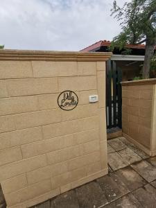 a fence with a wall with a sign on it at VILLA LORETTA in Torre dell'Orso