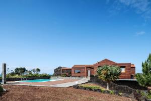 a wooden house with a swimming pool at Alma do Pico - Nature Residence in Madalena