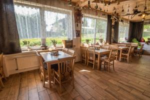a restaurant with wooden tables and chairs and windows at Pension Arberwald in Bayerisch Eisenstein
