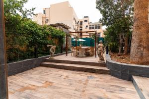 a garden with two statues of people on a patio at Suite 1 at Palazzo Seraphim Boutique living in St Julians in St Julian's