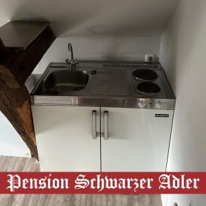 cocina con fregadero y fogones en Pension Schwarzer Adler, 